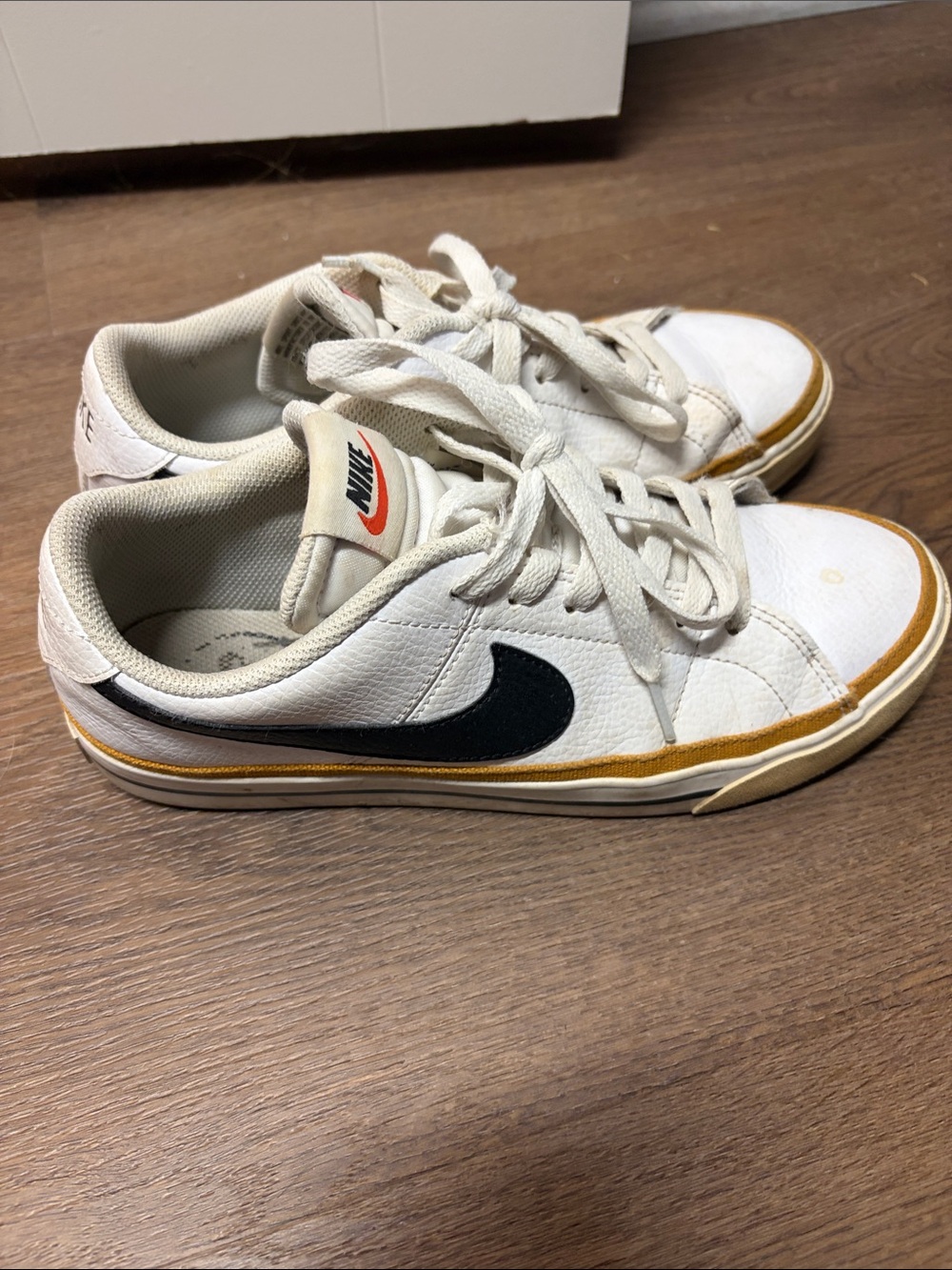 Nike White Sneakers with Black Swoosh and Gold Trim